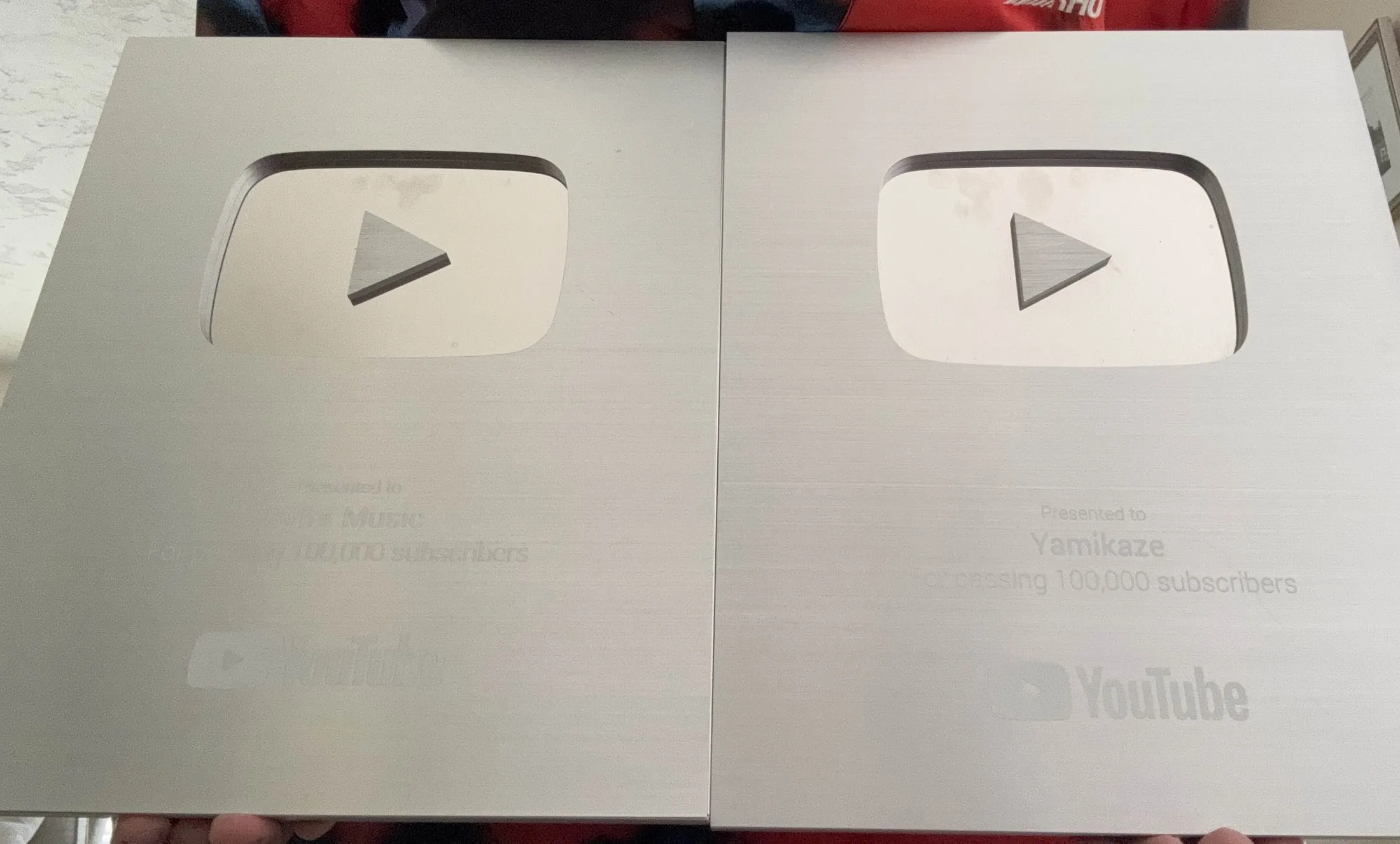 Two YouTube Silver Play Button awards presented to Syfer Music and Yamikaze for passing 100,000 subscribers